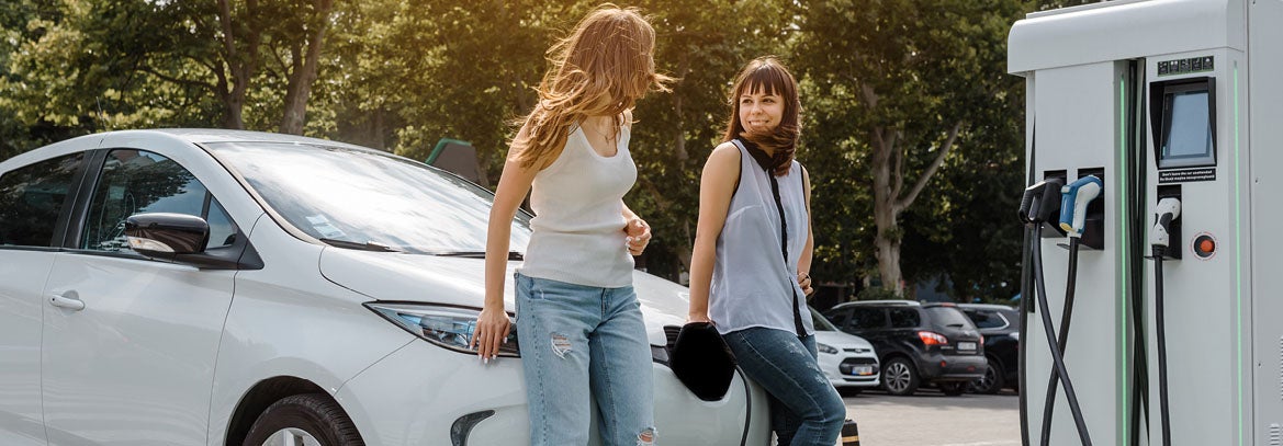 Young ladies charging an electric vehicle